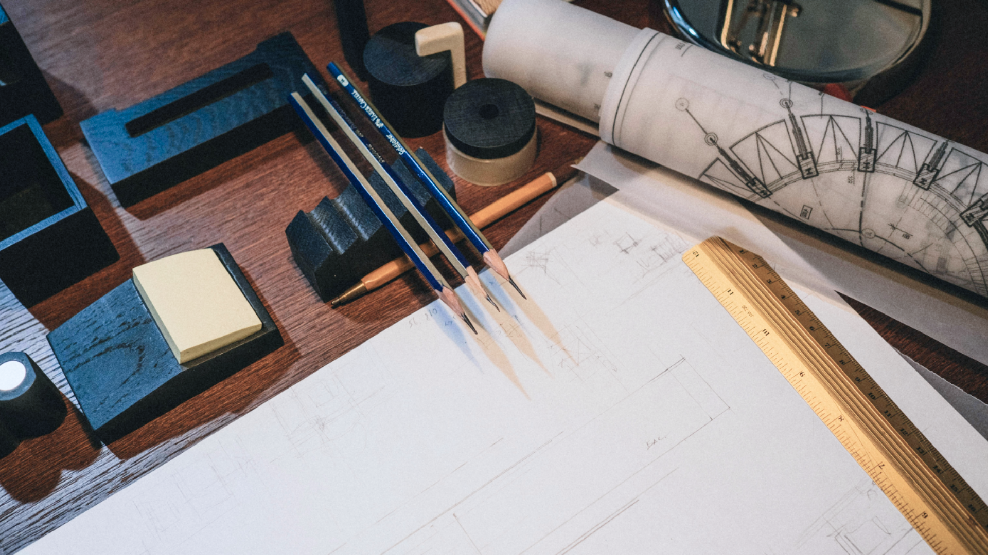 A workspace with architectural blueprints, wooden ruler, and sharp technical pencils, illustrating the careful planning and structural integrity required for data protection.