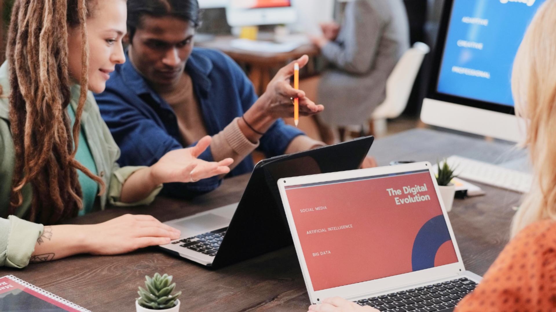 A diverse team of creative professionals collaborating in a modern office, discussing a digital presentation titled 'The Digital Evolution' on a laptop screen, emphasizing partnership and strategic growth.